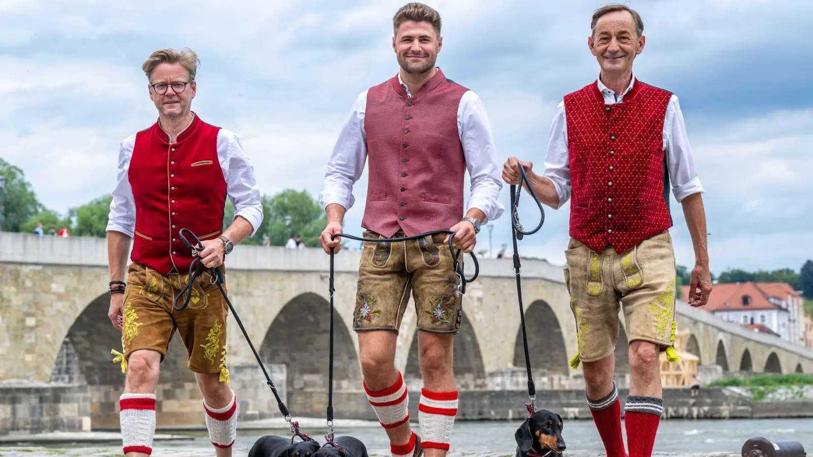 Mit einer Dackelparade wollen die Macher des Dackelmuseums, Oliver Storz (links), Moritz Hickl (Mitte) und Seppi Küblbeck (rechts), auf den kulturellen Wert der Dackelzucht aufmerksam machen. (Foto: Armin Weigel/dpa)