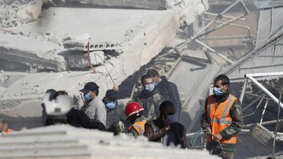 Rettungskräfte stehen in Damaskus an dem durch den Luftangriff zerstörten Gebäude. (Foto: Omar Sanadiki/AP/dpa)