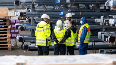 Ermittler und Polizisten stehen nahe der Unglücksstelle am Hamburger Hafen. (Foto: Jonas Walzberg/dpa)