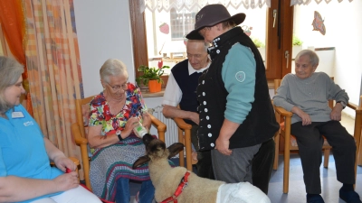 Hier bekommt Lamm Frieda gerade ihr Fläschchen im Gerlach-von-Hohenlohe-Stift. Schäferin Carmela Schulz besucht die Seniorinnen und Senioren regelmäßig mit dem jungen Schaf.  (Foto: Christa Frühwald)