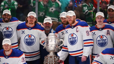 Leon Draisaitl posiert hinter Kapitän Connor McDavid mit dem Pokal für den Sieger der Western Conference. (Foto: Julio Cortez/AP/dpa)