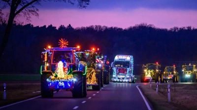 Weihnachtlich beleuchtete und geschmückte Traktoren und Lkw sind bei der Lichterfahrt der Oderlandbauern in Brandenburg unterwegs.  (Foto: Patrick Pleul/dpa)