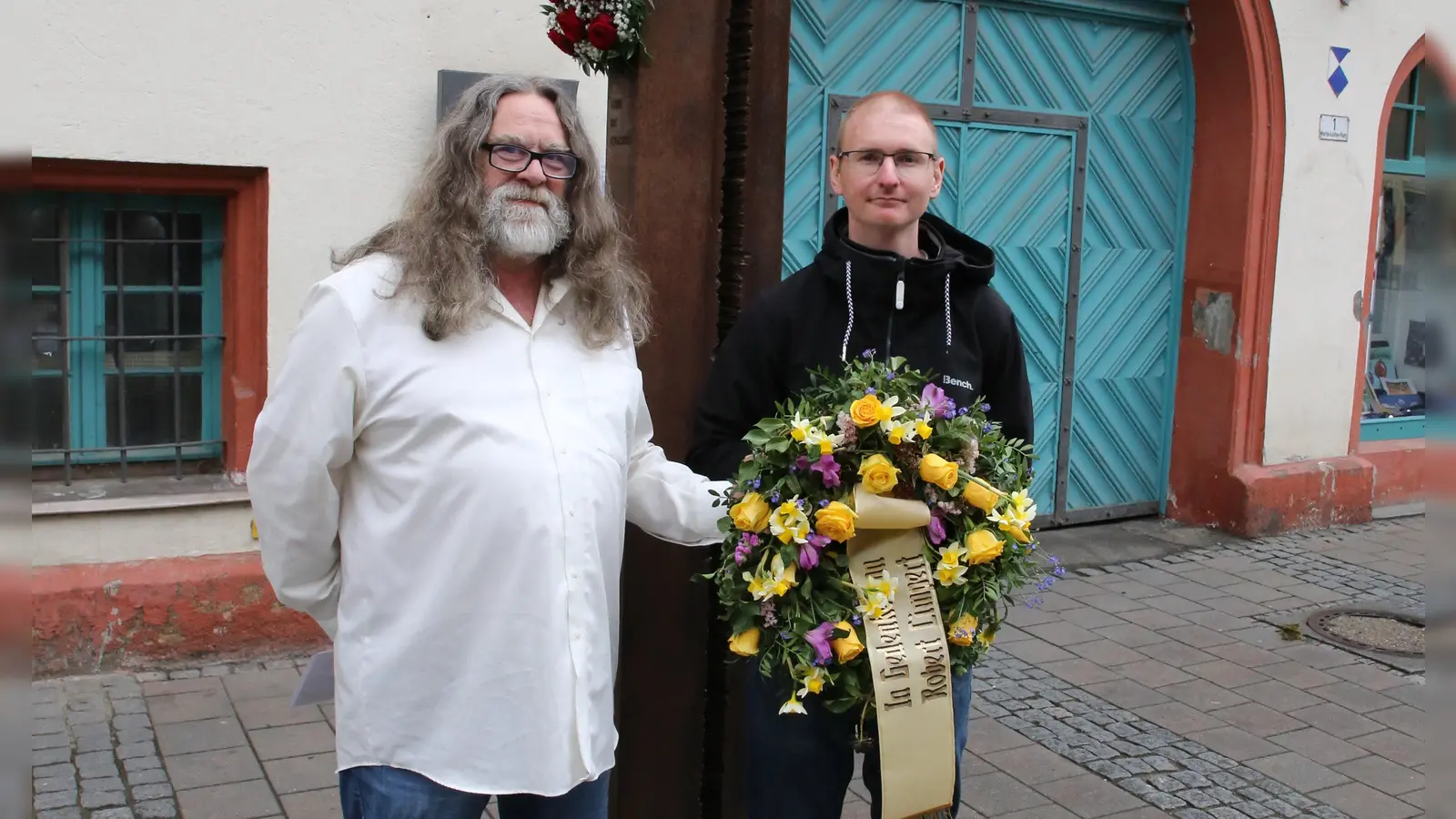 Hannes Hüttinger (links) hat mit Axel Ludwig Setzer einen Kranz für Robert Limpert vor dem Ansbacher Rathaus niedergelegt. (Foto: Alexander Biernoth)