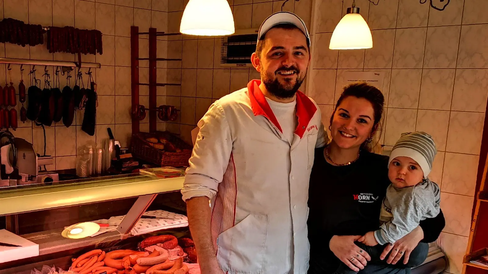 Maximilian Horn hofft darauf, dass Sohn Theo den Betrieb einmal übernimmt. Seine Frau Sarah Horn ist fest in die Leitung integriert. Das Foto entstand im Hofladen in Kreuth. (Foto: Laura Eyrich)