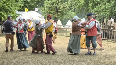 Die Strawanzerey aus Herrieden zeigte historische Tänze – dahinter steigt der Rauch aus der Schmiede auf. (Foto: Margit Schwandt)