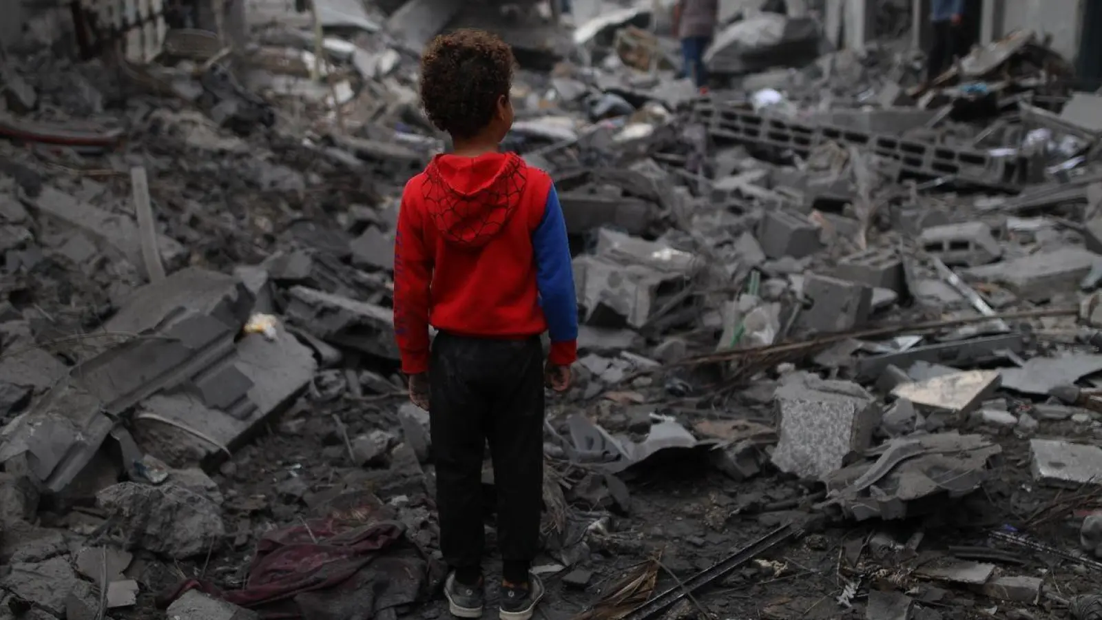 Ein Junge steht vor den Trümmern nach einem Luftangriff im Flüchtlingslager Maghazi im Zentrum des Gazastreifens. Schon sechs Monate lang tobt der Gaza-Krieg. (Foto: Uncredited/XinHua/dpa)