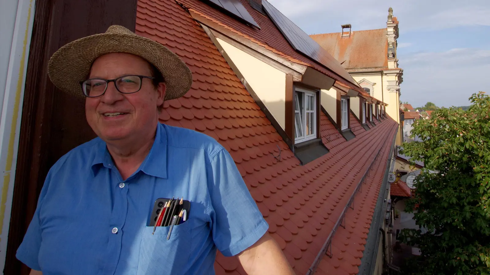 Jürgen Strauß vor dem rötlichen Brauhausdach mit PV-Anlagen. (Foto: Heinz Wraneschitz)