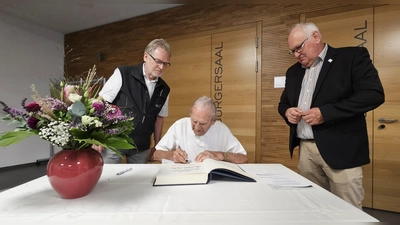 Stanislaus Sacha beim Eintrag ins Goldene Buch der Gemeinde Weidenbach. Sein Sohn Helmut (links) und Bürgermeister Willi Albrecht assistierten ihm. (Foto: Wolfgang Grebenhof)