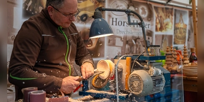 Beim Drechselmeister Horst Hager fliegen die Späne, als er eine kleine Ahornschale mit den Werkzeugen an seiner Drechselbank in Form bringt. (Foto: Mirko Fryska)