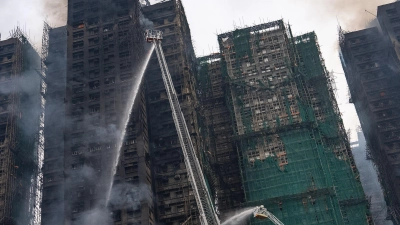 Auch fast 20 Stunden nach Ausbruch des Feuers kämpften die Einsatzkräfte noch gegen Flammen. (Foto: Chan Long Hei/AP/dpa)