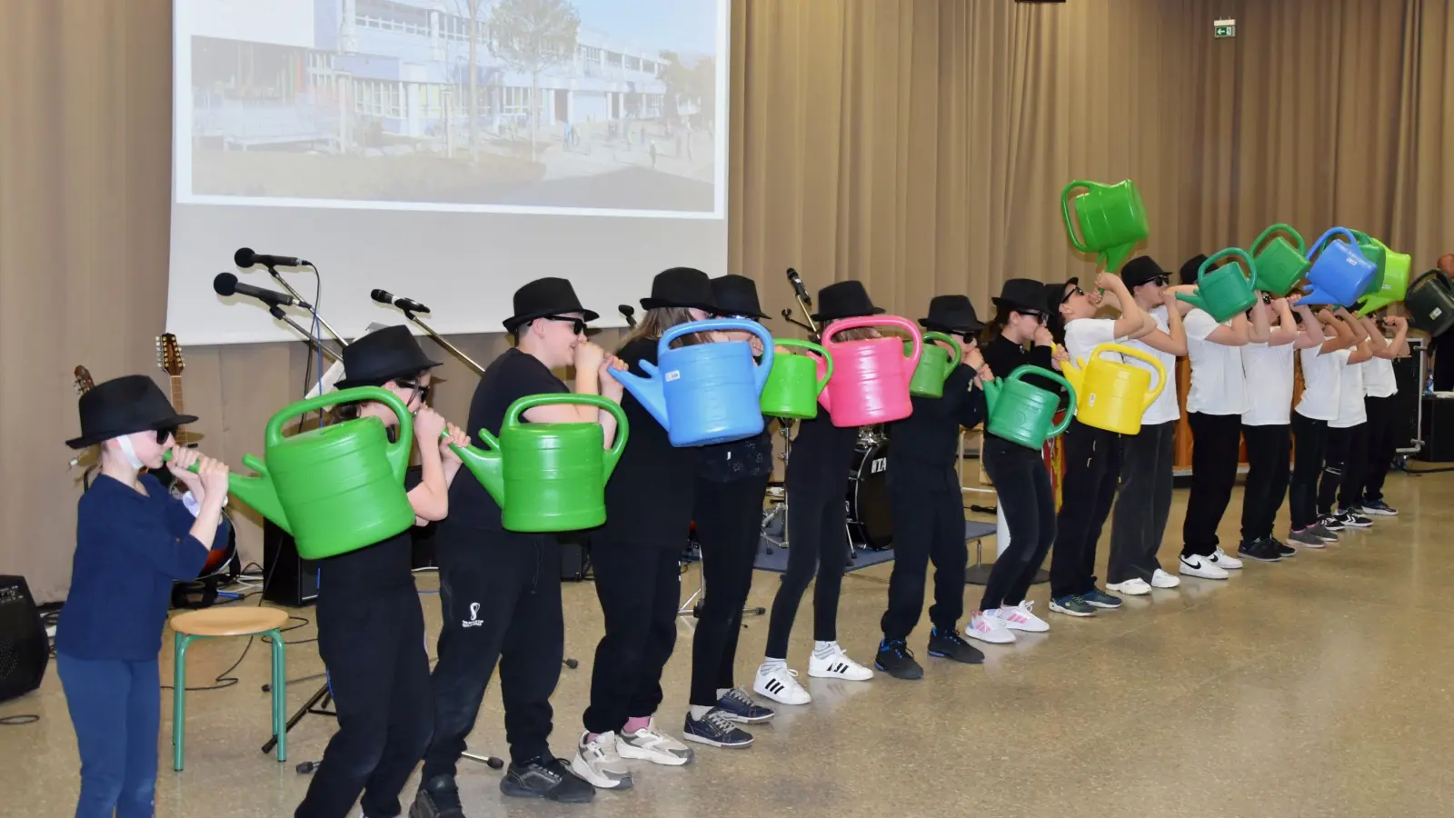 Als lustiges Gießkannen-Orchester trug die Klasse 4a zum stimmungsvollen Rahmenprogramm des Herrieder Schuljubiläums bei. (Foto: Werner Wenk)