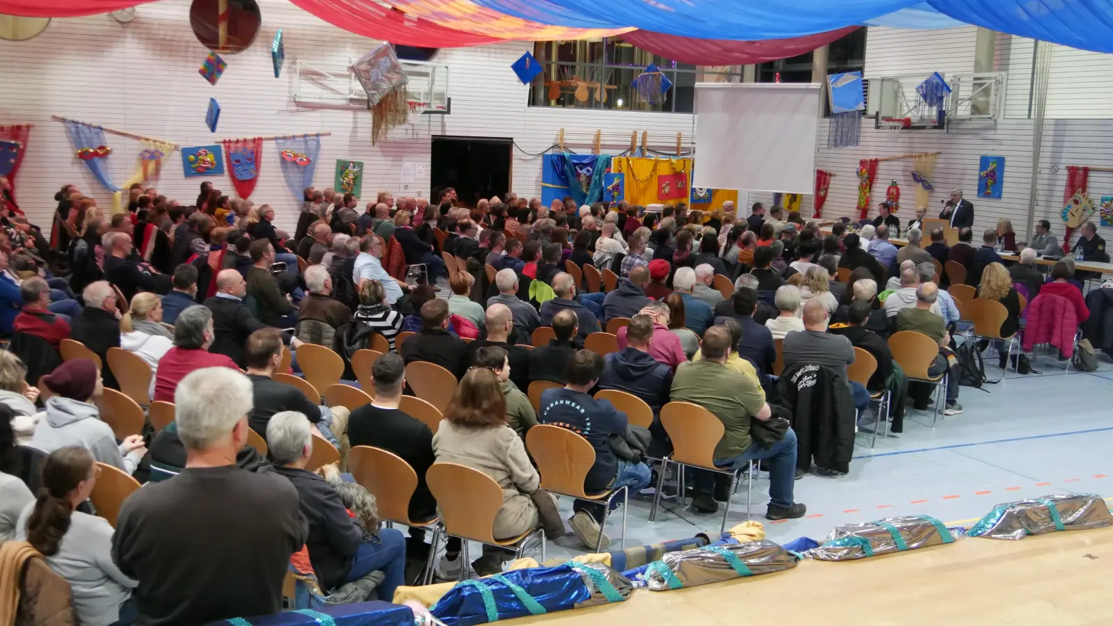 Die Rangauhalle ist für den Fasching geschmückt. Im Kontrast zur Dekoration stand das ernste Thema, das bei der Bürgerversammlung mit Rekordbeteiligung erörtert wurde: die Unterbringung von 40 geflüchteten Menschen. (Foto: Ulli Ganter)