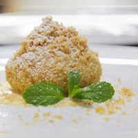 Puderzucker, süße Streusel - und drinnen die Sommerfrucht: Marillenknödel sind eine Genießer-Süßspeise. (Foto: Beate Wöllstein/Wöllsteins Desserthaus/dpa-tmn)