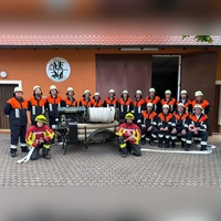 Auf 25 Aktive bringt es die Feuerwehr Tauberscheckenbach derzeit. Ein paar davon fehlen auf dem Foto mit der alten Spritze aus dem letzten Jahrhundert als Blickfang. Kommandant Denny Döppert ist sitzend als Vierter von rechts zu sehen, vorne die Atemschutzräger Leander Bach (links) und Uwe Stahl. (Foto: Freiwillige Feuerwehr Tauberscheckenbach)