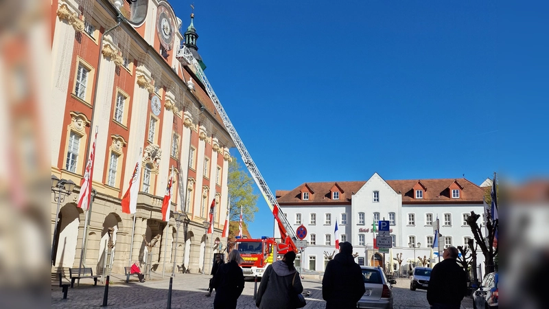 Der ungewöhnliche Einsatz der Feuerwehr an der Rathaus-Uhr in Bad Windsheim erregte bei den vorbeigehenden Menschen große Aufmerksamkeit. (Foto: Josh Reuter)