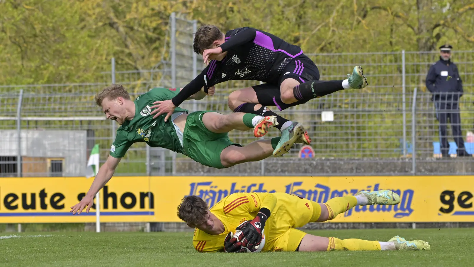 Abgehoben: Niklas Seefried von der SpVgg Ansbach (grünes Trikot) und Grayson Dettoni vom FC Bayern München II beim Überflug von Bayern-Torwart Tom Ritzy Hülsmann.  (Foto: Martin Rügner)