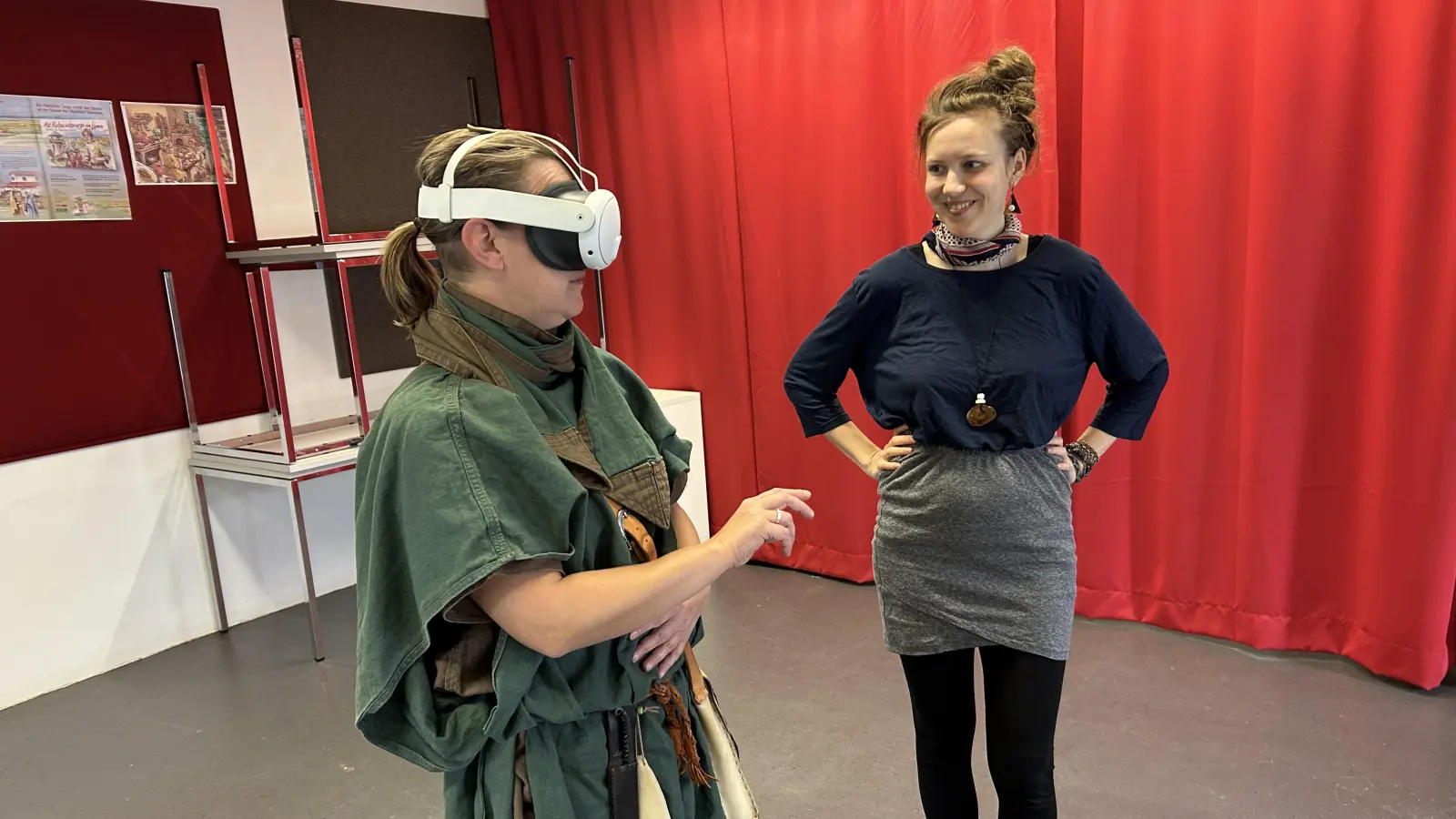 So sieht das Ganze von außen aus: Eine Römerin von der Soldatentruppe des Limeseums schaut sich virtuell die Küche an, Jenny Haase-Rieger (rechts) erklärt die Anwendung. (Foto: Matthias Pausch)