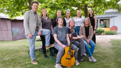 Freuen sich auf ein Open-Air-Konzert im Pfarrgarten: Chorleiterin Karin Dietlein (mit Gitarre), Pfarrerin Simone Sippel (rechts neben ihr), Sänger David Lugert und der „Chor ohne Namen”.  (Foto: Martin Stumpf)