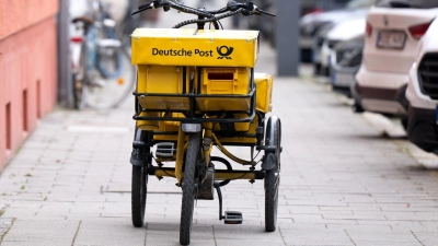 Ein Fahrrad eines Briefträgers steht auf einem Gehweg - auch dieser Briefträger möchte vermutlich gern deutlich besser bezahlt werden. (Foto: Sven Hoppe/dpa)