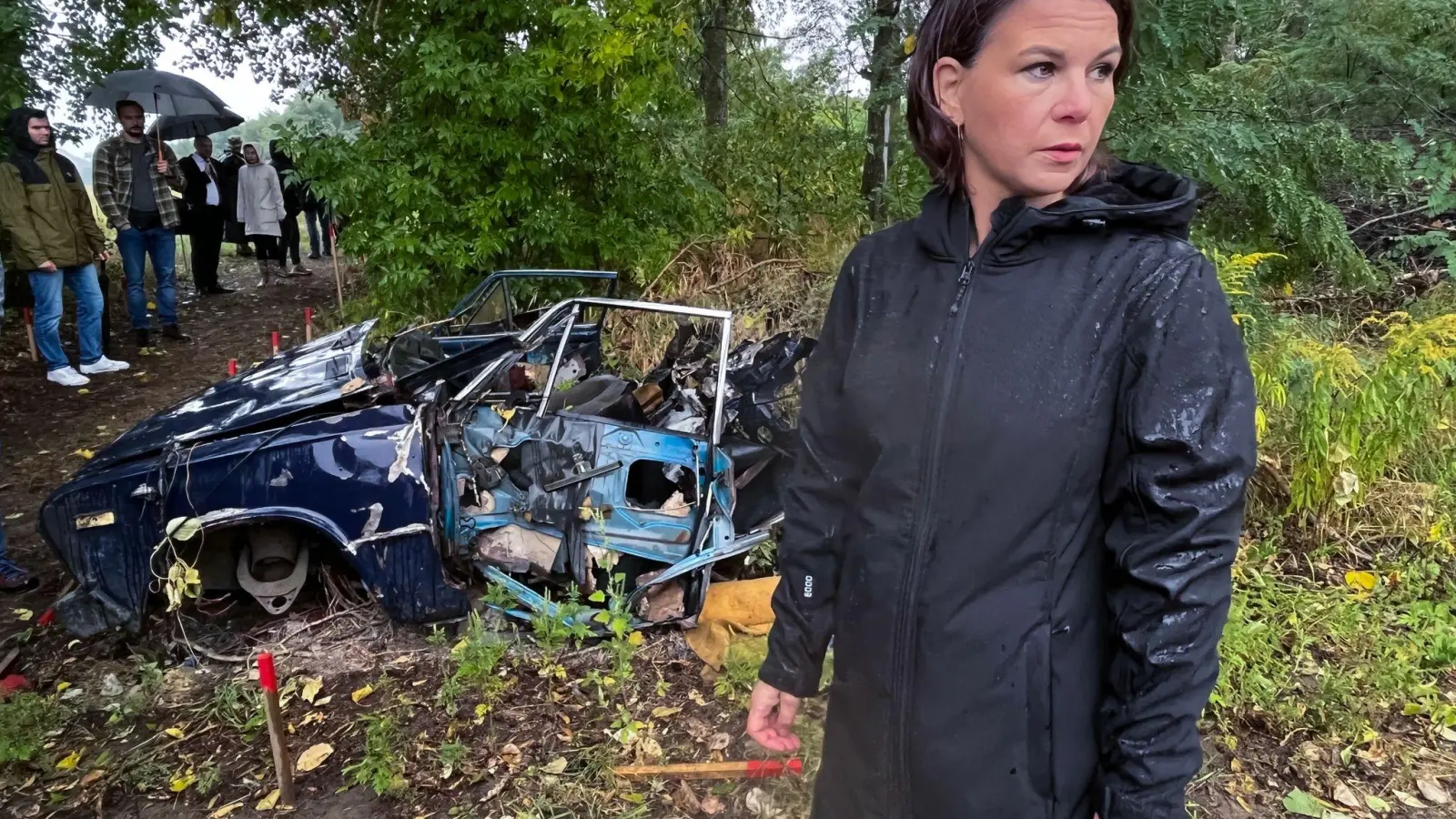 Außenministerin Baerbock besichtigt ein von Deutschland gefördertes Minenräumprojekt in der Nähe von Kiew. Das Auto im Hintergrund ist durch eine Mine zerstört worden. (Foto: Michael Fischer/dpa)