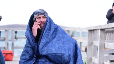 Robert Marc Lehmann geht auf Tuchfühlung mit einem gestrandeten Wal in der Ostsee.  (Foto: Daniel Bockwoldt/dpa)