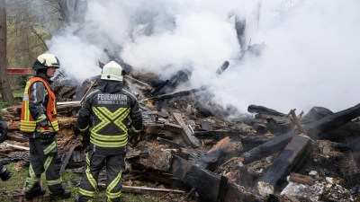 Feuerwehrleute stehen neben den noch rauchenden Trümmern des ehemaligen Hauses des „Kannibalen von Rotenburg“. (Foto: Boris Roessler/dpa)