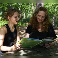 „KiPrax”-Praktikantin Zuhra Murati (links) bespricht ein Bilderbuch mit ihrer Praxisanleiterin Sandra Besold. (Foto: Tobias Völker)