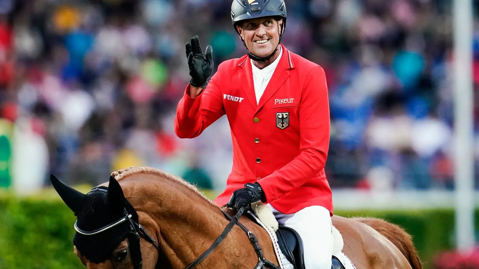 Springreiter André Thieme auf Chakaria winkt ins Publikum. (Foto: Uwe Anspach/dpa)