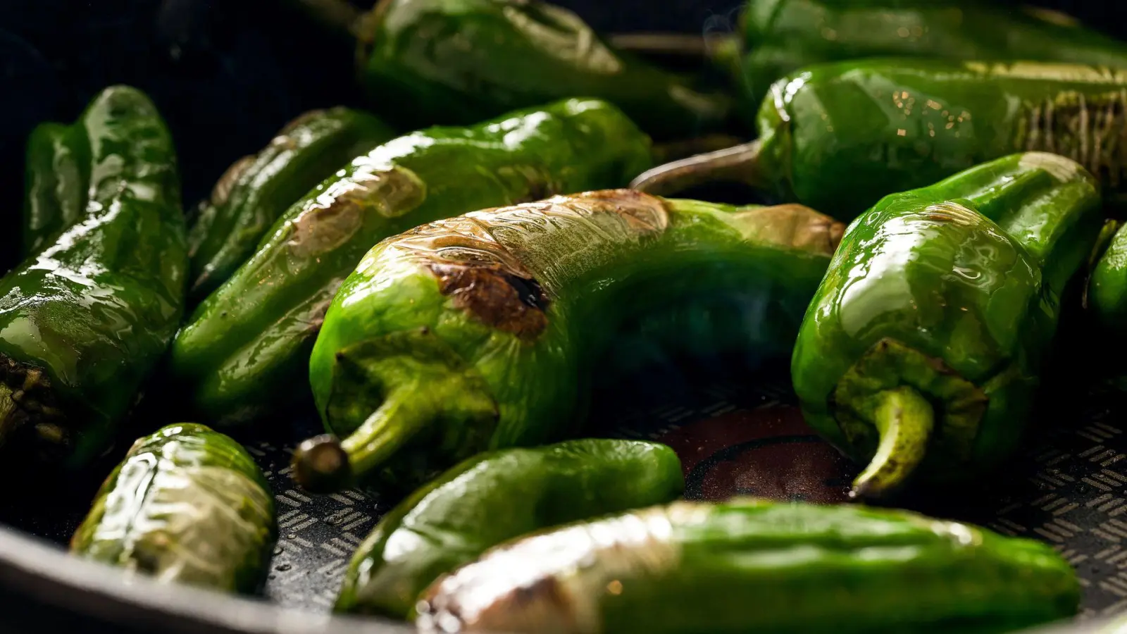 Grüne Grill- und Bratpaprika werden in einer Pfanne mit Olivenöl zubereitet und heiß als Snack oder Vorspeise mit Baguettes serviert. (Foto: Michael Bihlmayer/CHROMORANGE/dpa-tmn)