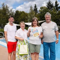 Die Freibadmitarbeiter Michael Reuter (links) und Bernd Wirth sowie Bürgermeisterin Claudia Wust (Zweite von links) gratulierten Vera Goda. Sie war Mittwoch der 30.000. Gast in dieser Saison im Neuhöfer Freibad. (Foto: Heidi Reuter)