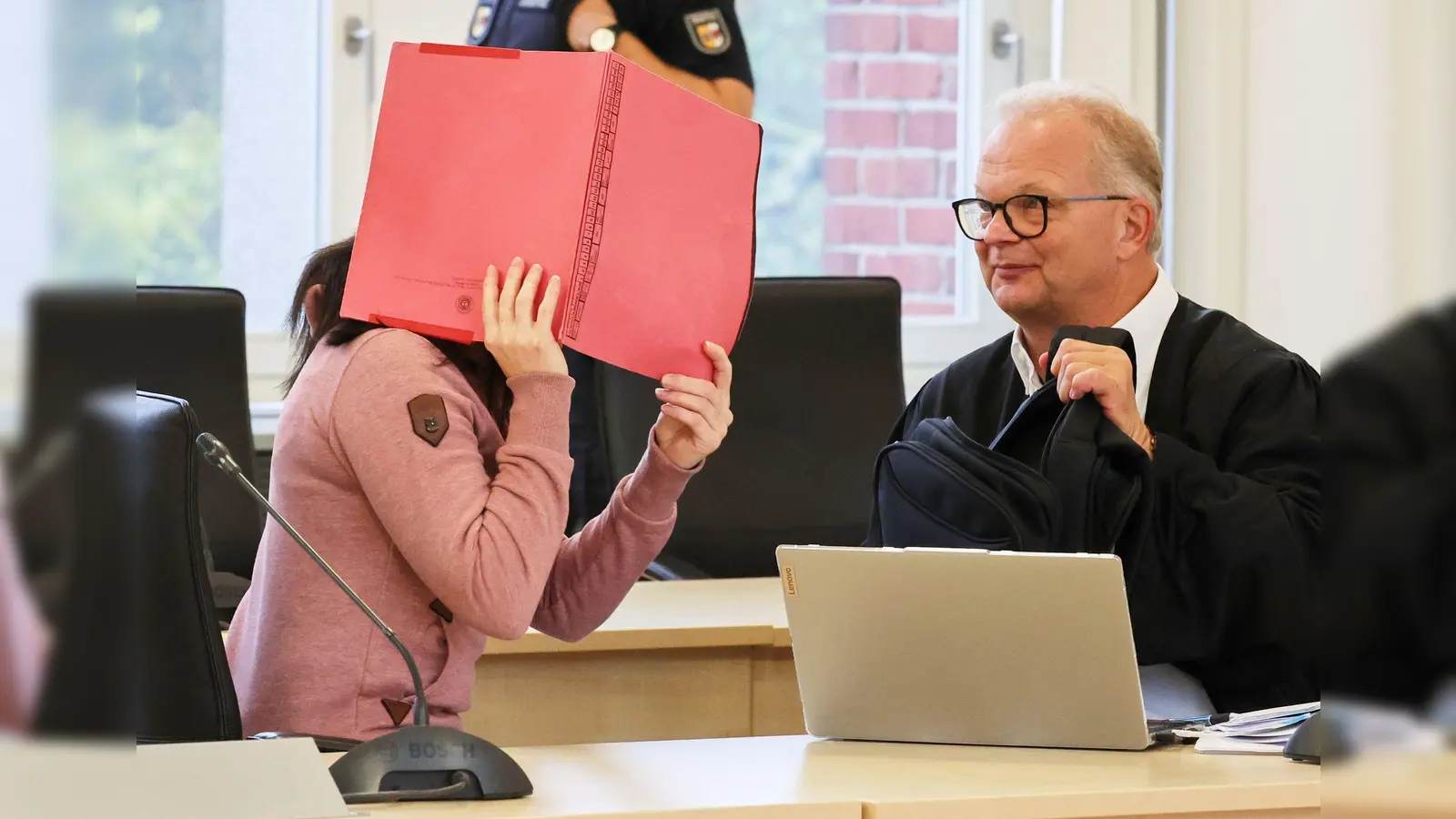 Die Angeklagte betritt den Gerichtssaal seit Monaten mit Fußfesseln und einem Aktendeckel vor dem Gesicht.  (Foto: Bernd Wüstneck/dpa)