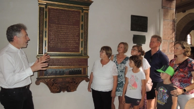 Am Epitaph für Feuchtwangens Reformator Georg Vogtherr in der Stiftskirche: Bei seiner Führung am gestrigen Tag des offenen Denkmals berichtete Pfarrer Michael Wild (links) seinen Begleitern Wissenswertes über historische Persönlichkeiten, die in Verbindung mit dem stadtbildprägenden Gotteshaus bekannt sind. (Foto: Peter Zumach)