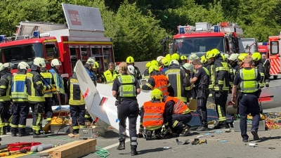 Rettungsdienste und Polizei arbeiten an der Unfallstelle, nachdem ein Segelflugzeug auf die A45 gestürzt ist.  (Foto: Berthold Stamm/dpa)