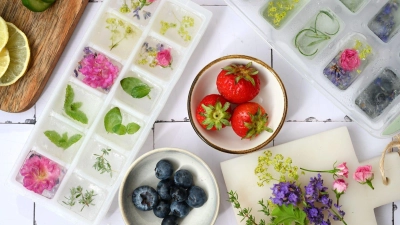 Durch schichtweises Einfrieren von Beeren, Blüten und Kräutern werden einfache Eiswürfel zu kleinen Kunstwerken. (Foto: Julia Uehren/loeffelgenuss.de/dpa-tmn)