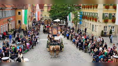 Farbenprächtiger Moment bei Mooswiesenfestzug auf dem Marktplatz: Die Zuschauerinnen und Zuschauer bewundern den Motivwagen „Wolgemuth – Meister des Feuchtwanger Marienaltars. (Foto: Kai Schlichtermann)