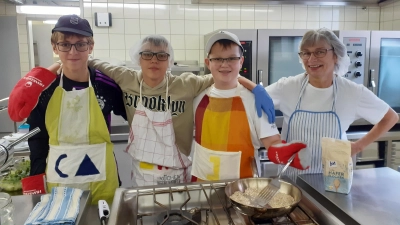 Clemens Weber, Linus Weick und Janne Mayer (von links) gehen Hauswirtschaftsmeisterin Erni Hübsch zur Hand und helfen in der Großküche der Edith-Stein-Realschule mit. (Foto: Marcus Pfalzer)
