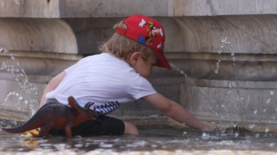 Ein Kind kühlt sich bei 38 Grad Celsius an einem Brunnen ab. (Foto: Gao Jing/XinHua/dpa)