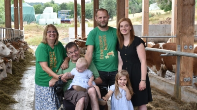Familie Mondel im neu gebauten Kuhstall, von links Beate, Helmut und Hofbetreiber Simon Mondel, seine Frau Petra Schilling und vorne die dritte Generation Liora und Emelie. (Foto: Anita Dlugoß)