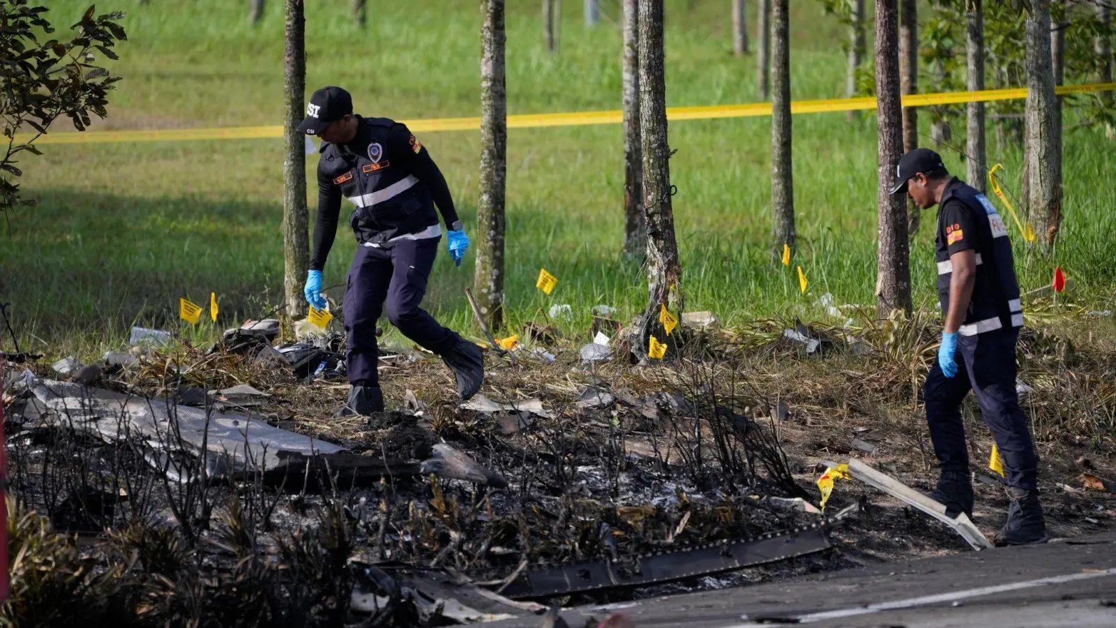 Polizisten ermittelt an der Absturzstelle des Kleinflugzeugs in Malaysia. (Foto: Vincent Thian/AP)