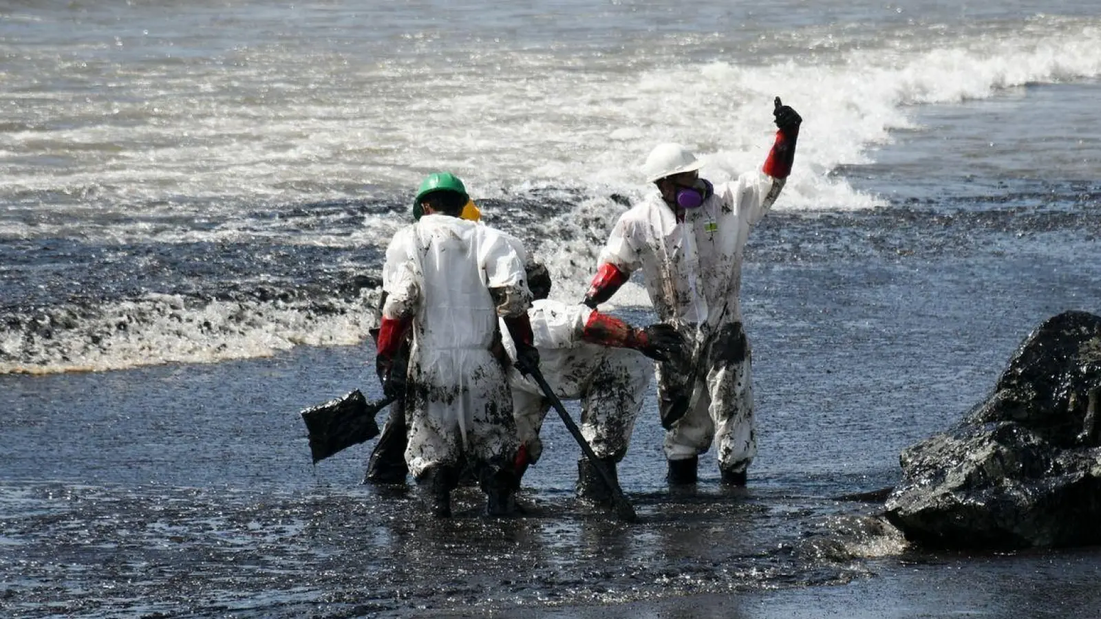 Arbeiter beseitigen einen Ölteppich, der den Strand von Rockly Bay in Scarborough im Südwesten Tobagos erreicht hat. (Foto: Akash Boodan/AP/dpa)