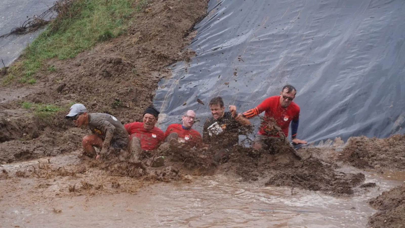 Ganz schön dreckig werden die Teilnehmenden des Ansbogger Mud Runs auf dem Parcours in der Shipton-Kaserne, während sie die Hindernisse überqueren. (Foto: Paul Wiese)