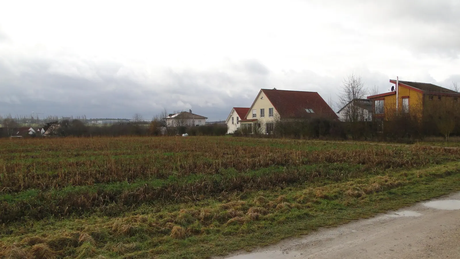 Auf diesem Acker sollen fünf Eigenheime entstehen. Dazu muss der Feldweg im Vordergrund zu einer Straße ausgebaut werden. (Foto: Winfried Vennemann)