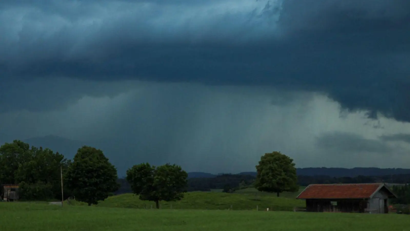 Dunkle Gewitterwolken hängen über der  Landschaft in Penzberg (Oberbayern). Der Deutsche Wetterdienst hat vor Unwettern in weiten Teilen Süddeutschlands gewarnt. (Foto: Alexander Wolf/dpa)