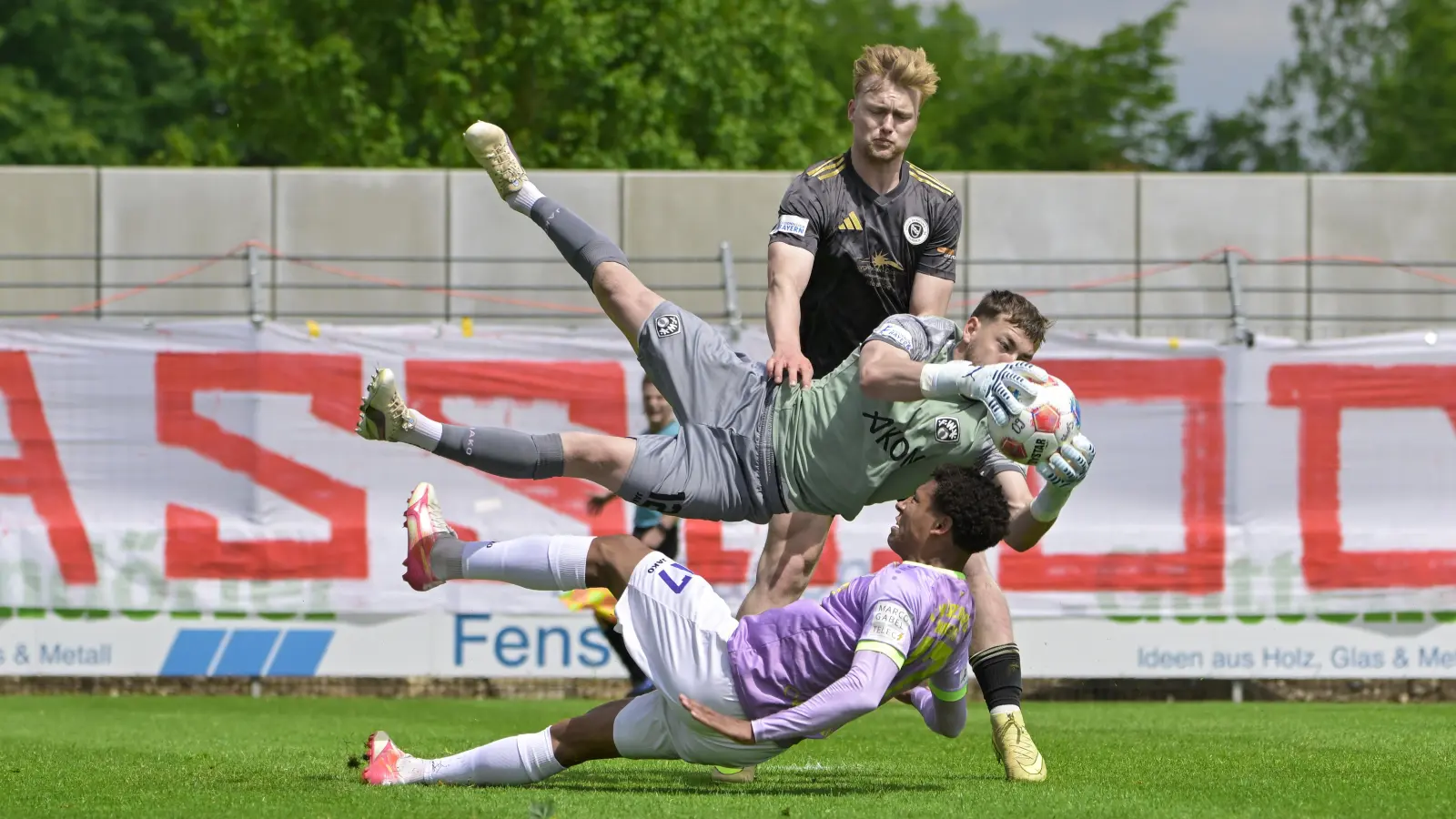 Voller Einsatz, um Ansbachs Niklas Seefried (in Schwarz) vom Torabschluss abzuhalten: Torwart Nick Guttenberger und Innenverteidiger Liam Omore von den Kickers Würzburg. (Foto: Martin Rügner)