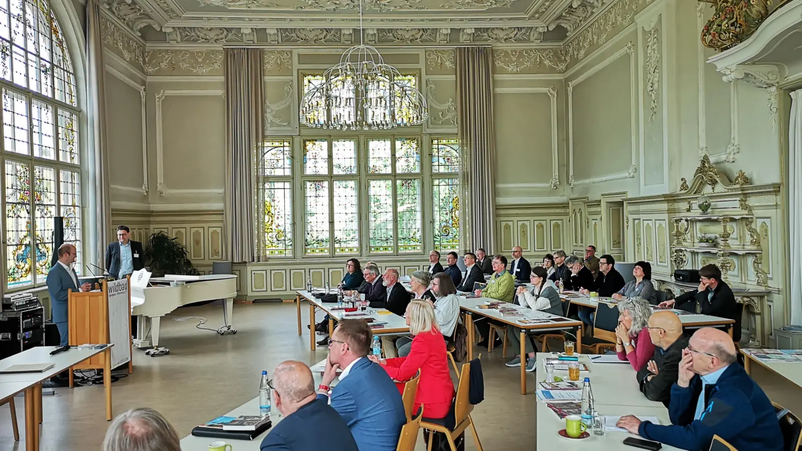 Im Rokokosaal des Wildbads lässt es sich gepflegt tagen. Das Foto entstand bei der Begrüßungsansprache von Oberbürgermeister Dr. Markus Naser (links). Rechts neben ihm: Stadtarchivar Dr. Florian Huggenberger, der das Programm mitorganisiert hatte. (Foto: Jürgen Binder)