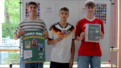 Die Zwölftklässler Josua Zimmermann, Paul Mantel und Nico Jenning (von links) vom Johann-Sebastian-Bach-Gymnasium Windsbach an ihrem Verkaufsstand für Sammelbilder in der Schulaula. (Foto: Constantin Prosch)