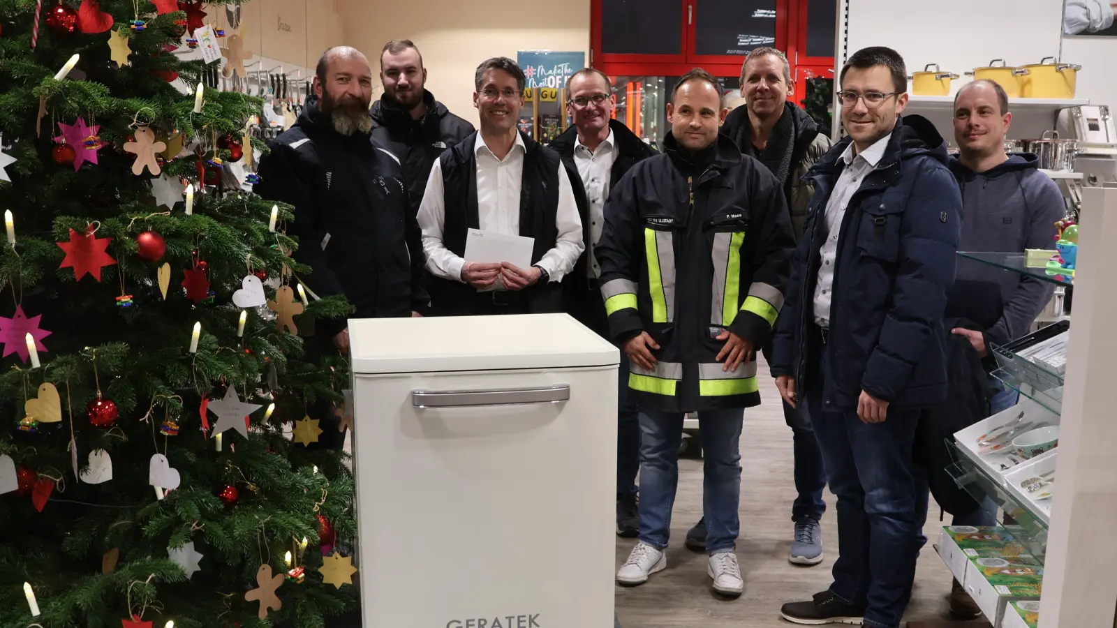 Zum firmeneigenen Wünschebaum hatte Geschäftsführer Gerd Müller (Dritter von links) die Spülmaschine für Dietmar Steinmetz (links) mit dazugestellt. Bürgermeister Toni Schiefer (Vierter von links) und eine fünfköpfige Ullstädter Feuerwehrdelegation nahmen das Gerät dort in Empfang (von rechts): Sven Wohlberedt, Bernd Eisenbeiß, Stefan Stäcker und Frank Maes sowie Niko Ziegler (Zweiter von links). (Foto: Andreas Reum)