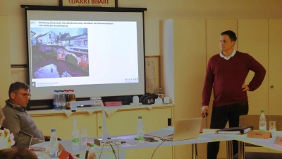 Ingenieur Uwe Reuther (stehend) erläuterte dem Markt Bibarter Ratsgremium den Sachstand zur Wiederherstellung der Altmannshäuser Brücke. Im Frühsommer soll die Sanierung beginnen. (Foto: Andreas Reum)