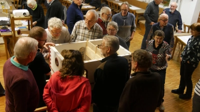 Sehr groß war das Interesse an der Präsentation des Modells der Synagoge. Das Dach lässt sich abnehmen; so kann man auch einen Blick ins Innere werfen. Der Modellbauer Robert Pümmerlein (hinten rechts, mit Bart) freute sich daran still und mit etwas Abstand. (Foto: Ulli Ganter)