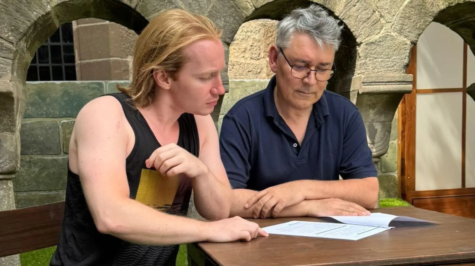 Sprachen im Vorfeld über die „Pumuckl”-Inszenierung im romanischen Geviert (von links): Kreuzgang-Schauspieler David Riedt, der auf der Bühne den Meister Eder gibt, und Regisseur Martin Piereth von der Bruckberger Theatergruppe Rampenlicht. (Foto: Kreuzgangspiele/Dr. Maria Wüstenhagen)